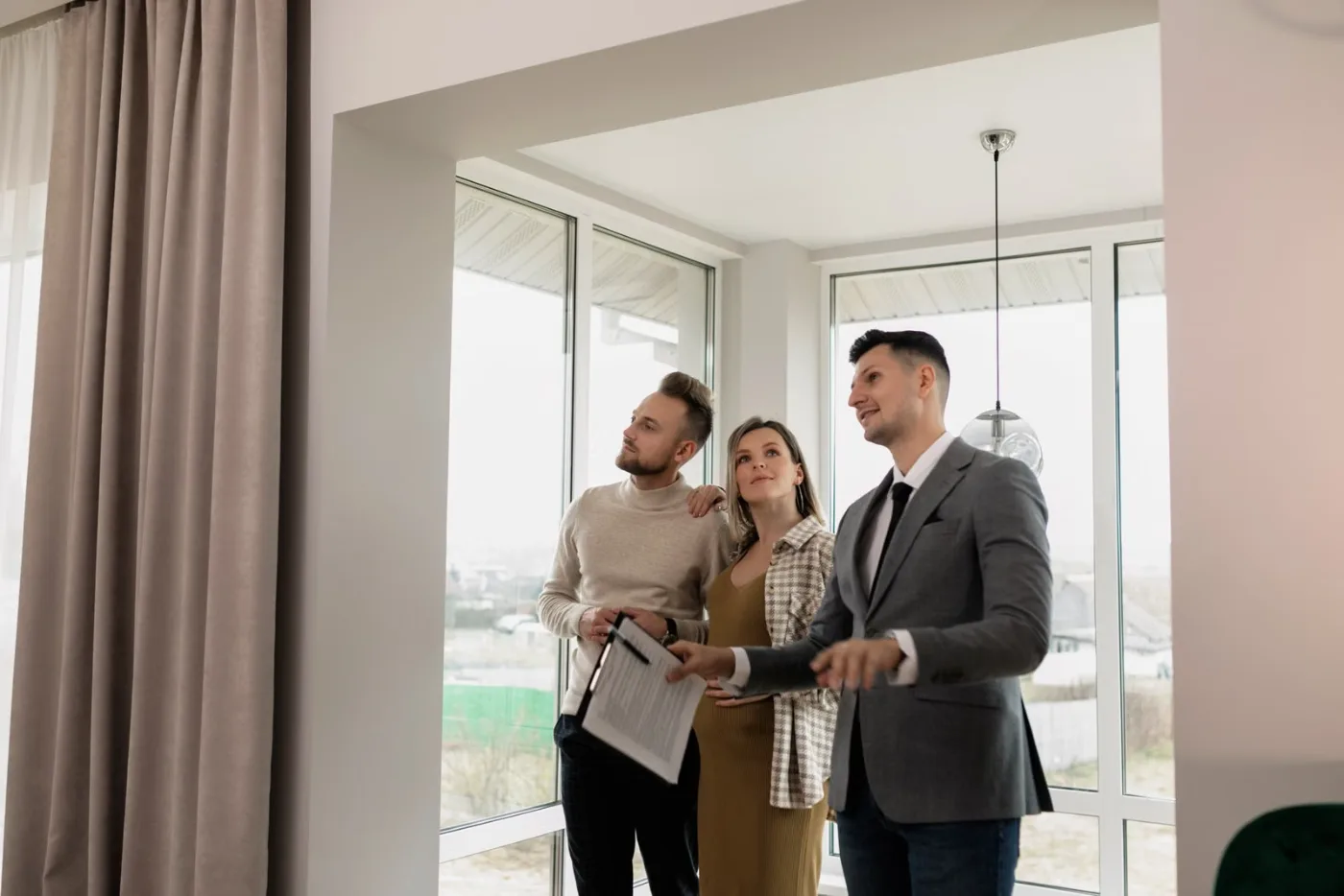 Agente entregando las llaves de una vivienda a sus nuevos propietarios
